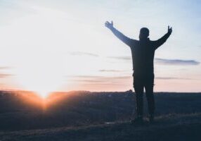 A,Man,With,Raised,Hands,Is,Praying.,On,The,Background