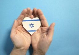 The concept of ending the war in Israel. heart in the colors of the flag of Israel in female hands